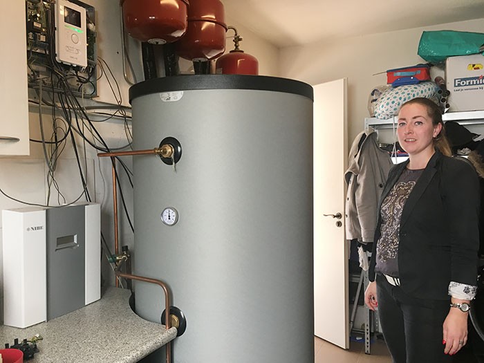 Desiree Kon naast het buffervat dat is aangesloten op de lucht/water warmtepomp Desiree Kon naast het buffervat dat is aangesloten op de lucht/water warmtepomp