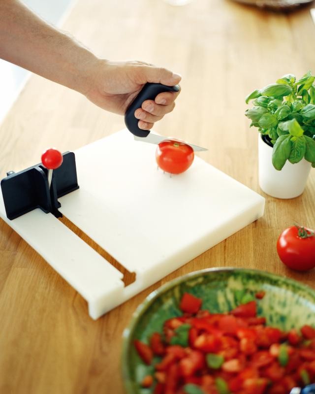 Snijden op een fixeerplank Tomaat snijden met aangepaste hulpmiddelen in de keuken