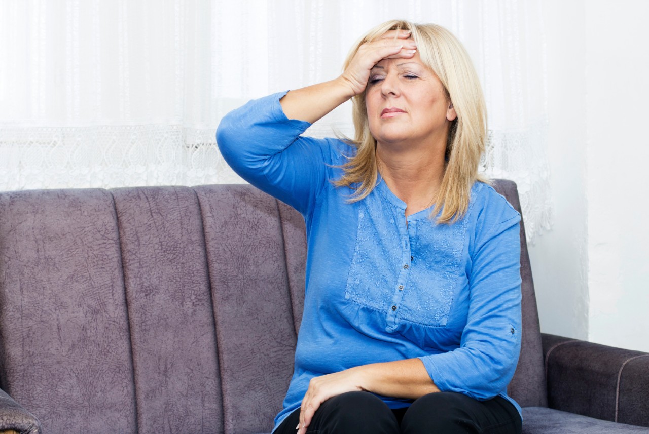 Mevrouw met hoofdpijn rust uit op haar bank Mevrouw met hoofdpijn rust uit op haar bank