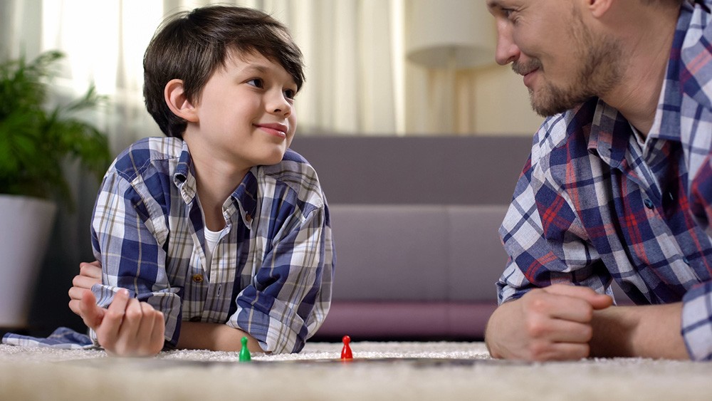 Vader en zoontje doen een bordspel Vader en zoontje doen een bordspel